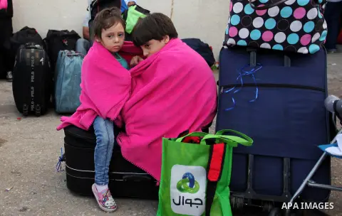 Palestinian chidren sit on a suitcase as they wait with their family for travel permits to cross into Egypt through the Rafah border crossing on October 15, 2016 in the southern Gaza Strip. Egyptian authorities temporari...