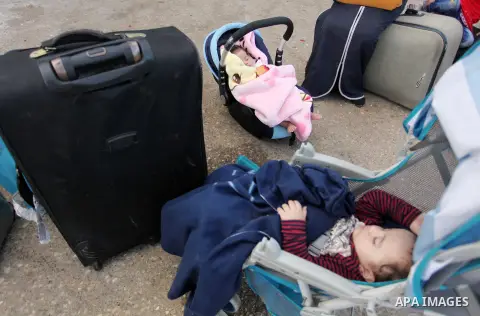 Palestinian childern sleep on a suitcase as they wait with their family for a travel permit to cross into Egypt through the Rafah border crossing on October 15, 2016 in the southern Gaza Strip. Egyptian authorities tempo...