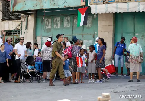 Israeli settlers visit the Jewish shrine of Atnaeil Ben Kinaz during the Jewish Sukkot holiday or the feast of the Tabernacles in a Palestinian neighbourhood of the divided West Bank city of Hebron on Oct. 19, 2016. Phot...