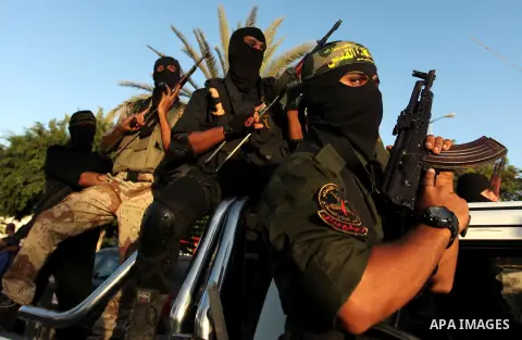 Palestinian Islamic Jihad militants hold their weapons during a military parade marking the 29 anniversary of their group in Gaza October 19, 2016. Photo by Ashraf Amra