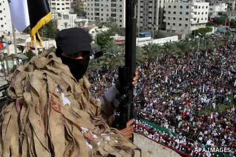 A Palestinian Islamic Jihad militant stands guard on a roof during a rally marking the 29th anniversary of the movement foundation in Gaza City October 21, 2016. Photo by Abed Rahim Khatib