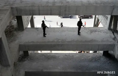 Palestinian Islamic Jihad militants stand guard on a roof during a rally marking the 29th anniversary of the movement foundation in Gaza City October 21, 2016. Photo by Abed Rahim Khatib