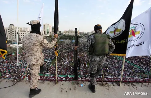 Palestinian Islamic Jihad militants stand guard on a roof during a rally marking the 29th anniversary of the movement foundation in Gaza City October 21, 2016. Photo by Ashraf Amra