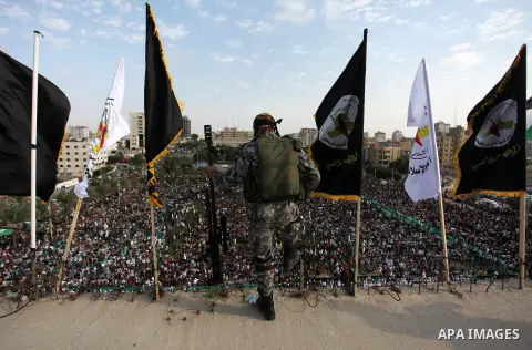 A Palestinian Islamic Jihad militant stands guard on a roof during a rally marking the 29th anniversary of the movement foundation in Gaza City October 21, 2016. Photo by Ashraf Amra