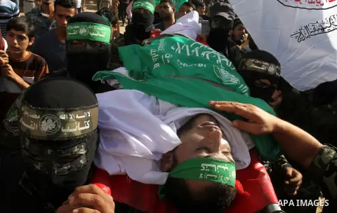 Members of the Ezzedine al-Qassam Brigades, the military wing of the Palestinian Islamist movement Hamas, carry the body of a fellow Palestinian militant, Amir Jaber Abu Taimeh, during his funeral in Khan Yunis in the so...