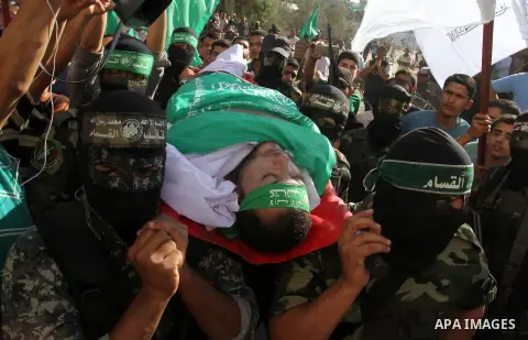 Members of the Ezzedine al-Qassam Brigades, the military wing of the Palestinian Islamist movement Hamas, carry the body of a fellow Palestinian militant, Amir Jaber Abu Taimeh, during his funeral in Khan Yunis in the so...