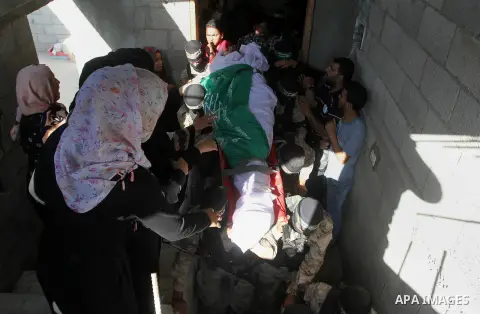 Members of the Ezzedine al-Qassam Brigades, the military wing of the Palestinian Islamist movement Hamas, carry the body of a fellow Palestinian militant, Amir Jaber Abu Taimeh, during his funeral in Khan Yunis in the so...