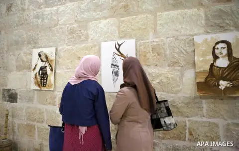 Palestinians attend a drawing exhibition titled "Tales of coffee-flavored", in the West Bank city of Ramallah, on October 25, 2016. Photo by Shadi Hatem