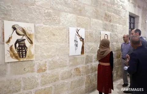 Palestinians attend a drawing exhibition titled "Tales of coffee-flavored", in the West Bank city of Ramallah, on October 25, 2016. Photo by Shadi Hatem