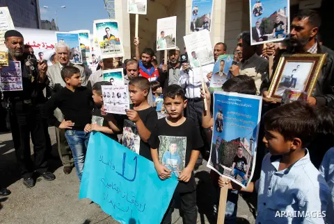 Palestinians hold banners during a protest demanding Israel return the bodies of Palestinians who allegedly stabbed Israelis, in the West Bank city of Hebron, on Oct. 28, 2016. Photo by Wisam Hashlamoun