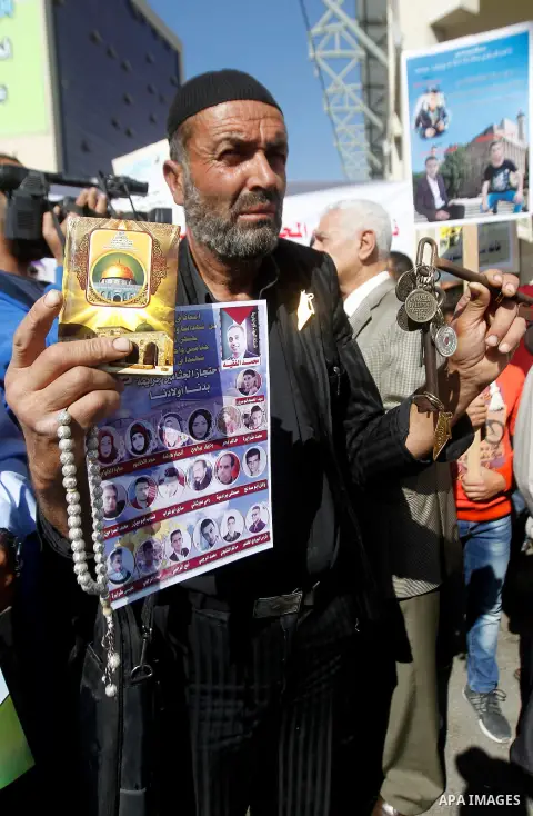 Palestinians hold banners during a protest demanding Israel return the bodies of Palestinians who allegedly stabbed Israelis, in the West Bank city of Hebron, on Oct. 28, 2016. Photo by Wisam Hashlamoun