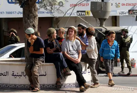 Israeli settlers take part in a protest against Palestinian stones throwers on October 28, 2016 on the main road of the village of Hawara in the northern West Bank. Photo by Nedal Eshtayah