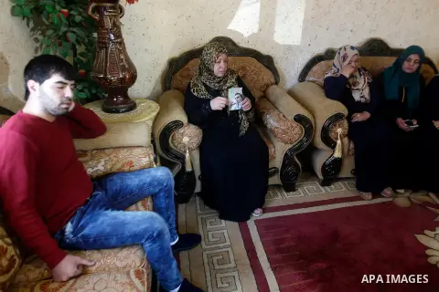 The mother of Palestinian Khaled Ekhlail holds the picture of her son in her house in the West Bank village of Beit Ummar, north of Hebron on October 31, 2016. Israeli army killing of Ekhlail on Sunday evening near Hebro...