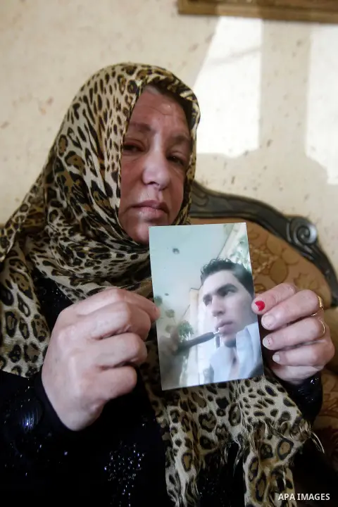 The mother of Palestinian Khaled Ekhlail holds the picture of her son in her house in the West Bank village of Beit Ummar, north of Hebron on October 31, 2016. Israeli army killing of Ekhlail on Sunday evening near Hebro...