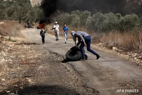 A Palestinian protester burns tires during clashes with Israeli security forces following a weekly demonstration against the expropriation of Palestinian land by Israel on Nov. 04, 2016, in the village of Kfar Qaddum, ne...