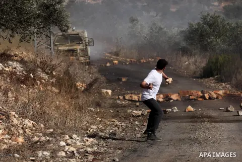 A Palestinian protester hurls stones towards Israeli security forces during clashes following a weekly demonstration against the expropriation of Palestinian land by Israel on Nov. 04, 2016, in the village of Kfar Qaddum...