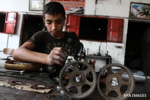 A Palestinian boy works at a mechanic shop in Rafah in the southern Gaza strip, on November 7, 2016. Photo by Abed Rahim Khatib