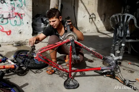 A Palestinian boy works at a mechanic shop in Rafah in the southern Gaza strip, on November 7, 2016. Photo by Abed Rahim Khatib