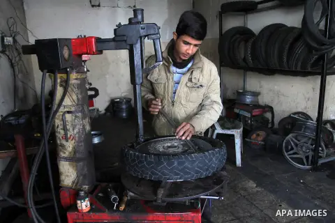 A Palestinian boy works at a mechanic shop in Rafah in the southern Gaza strip, on November 7, 2016. Photo by Abed Rahim Khatib