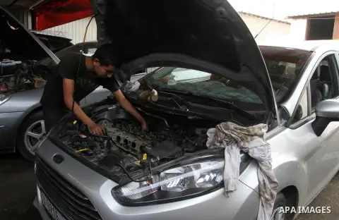 A Palestinian boy works at a mechanic shop in Rafah in the southern Gaza strip, on November 7, 2016. Photo by Abed Rahim Khatib