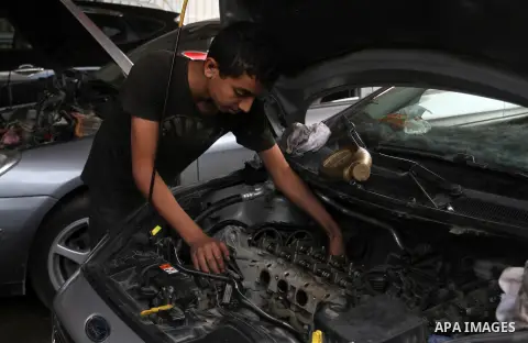 A Palestinian boy works at a mechanic shop in Rafah in the southern Gaza strip, on November 7, 2016. Photo by Abed Rahim Khatib