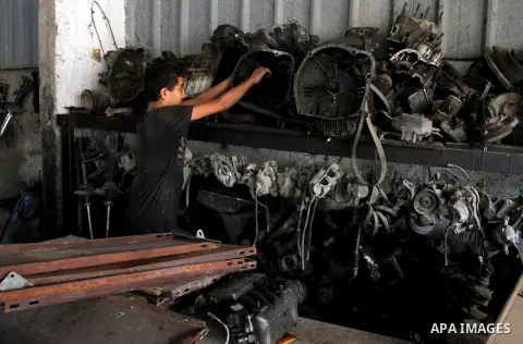 A Palestinian boy works at a mechanic shop in Rafah in the southern Gaza strip, on November 7, 2016. Photo by Abed Rahim Khatib