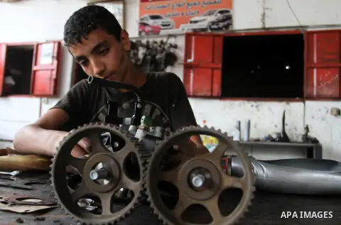 A Palestinian boy works at a mechanic shop in Rafah in the southern Gaza strip, on November 7, 2016. Photo by Abed Rahim Khatib
