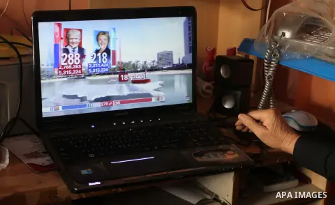 A Palestinian man watches broadcasting of the 2016 U.S. presidential election results on TV in Rahaf in the southern Gaza strip, on November 9, 2016. Republican Donald Trump has been elected the 45th president of the Uni...