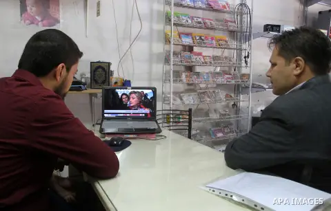 Palestinian men watch broadcasting of the 2016 U.S. presidential election results on TV in Rahaf in the southern Gaza strip, on November 9, 2016. U.S. Republican Donald Trump has been elected the 45th president of the Un...