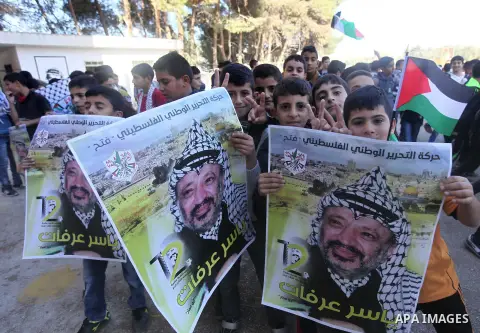 Palestinian school boys hold posters of the late Palestinian leader Yasser Arafat to mark the 12 anniversary of his death in the West Bank village of Salem just east of the city of Nablus on November 10, 2016. Photo by N...