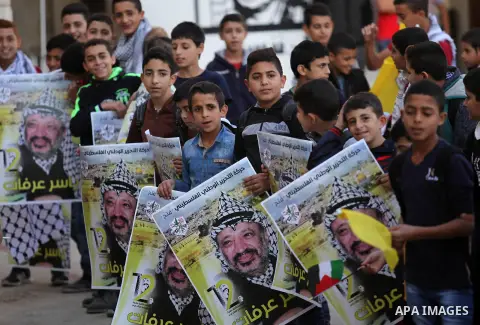 Palestinian school boys hold posters of the late Palestinian leader Yasser Arafat to mark the 12 anniversary of his death in the West Bank village of Salem just east of the city of Nablus on November 10, 2016. Photo by N...