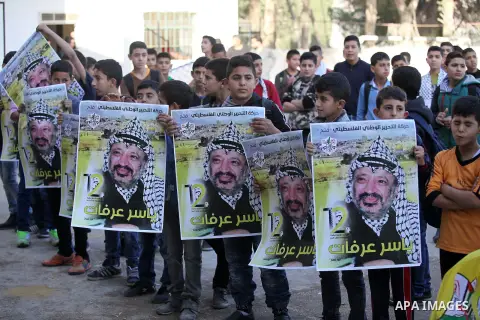 Palestinian school boys hold posters of the late Palestinian leader Yasser Arafat to mark the 12 anniversary of his death in the West Bank village of Salem just east of the city of Nablus on November 10, 2016. Photo by N...