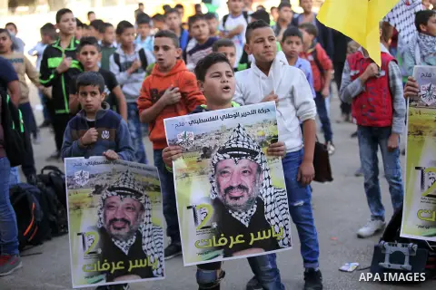 Palestinian school boys hold posters of the late Palestinian leader Yasser Arafat to mark the 12 anniversary of his death in the West Bank village of Salem just east of the city of Nablus on November 10, 2016. Photo by N...