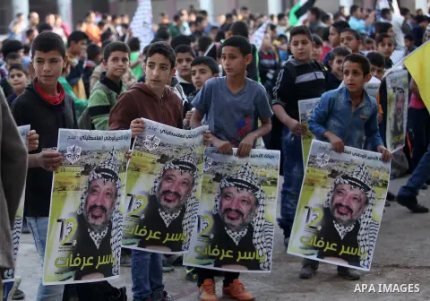 Palestinian school boys hold posters of the late Palestinian leader Yasser Arafat to mark the 12 anniversary of his death in the West Bank village of Salem just east of the city of Nablus on November 10, 2016. Photo by N...