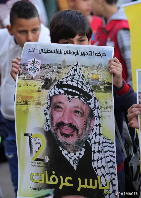 Palestinian school boys hold posters of the late Palestinian leader Yasser Arafat to mark the 12 anniversary of his death in the West Bank village of Salem just east of the city of Nablus on November 10, 2016. Photo by N...