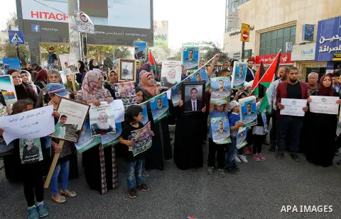 Palestinians hold banners during a protest demanding Israel return the bodies of Palestinians who allegedly stabbed Israelis, in the West Bank city of Hebron, on Nov. 13, 2016. Photo by Wisam Hashlamoun