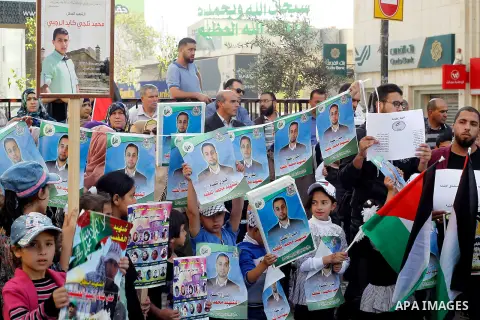 Palestinians hold banners during a protest demanding Israel return the bodies of Palestinians who allegedly stabbed Israelis, in the West Bank city of Hebron, on Nov. 13, 2016. Photo by Wisam Hashlamoun