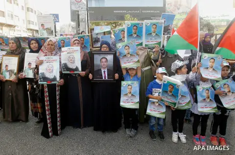 Palestinians hold banners during a protest demanding Israel return the bodies of Palestinians who allegedly stabbed Israelis, in the West Bank city of Hebron, on Nov. 13, 2016. Photo by Wisam Hashlamoun