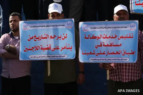 Palestinians hold banners during a protest against the UNRWA decision to reduce of the aid in front of the headquarters United Nations Relief and Works Agency (UNRWA), in Gaza city, on Nov. 14, 2016. Photo by Mohammed As...