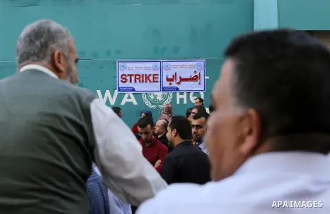 Palestinians hold banners during a protest against the UNRWA decision to reduce of the aid in front of the headquarters United Nations Relief and Works Agency (UNRWA), in Gaza city, on Nov. 14, 2016. Photo by Mohammed As...