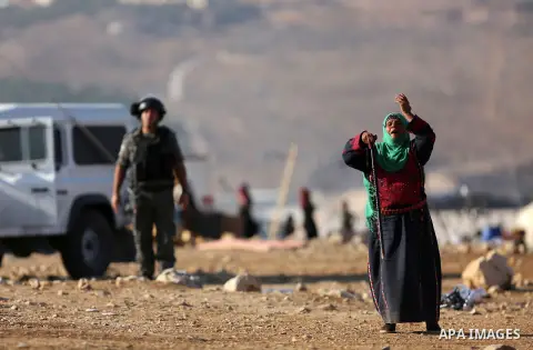 A Palestinian Bedouin woman reacts as Israeli security forces confiscate barracks in the Bedouin residential area after Israeli authorities said it was built without a permit in the West Bank village of Jab'a, north east...