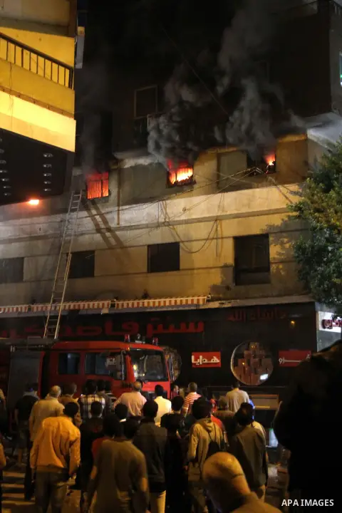 Egyptians gather as Civil defense firefighters effort to control a fire that broke out in a store in the Fagala district of Cairo on November 16, 2016. Photo by Amr Sayed