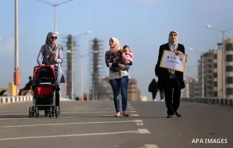 Palestinian women march on a street, calling for the rehabilitation of marginalised women in Gaza City on November 17, 2016. Photo by Yasser Qudih