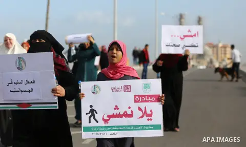 Palestinian women march on a street, calling for the rehabilitation of marginalised women in Gaza City on November 17, 2016. Photo by Yasser Qudih
