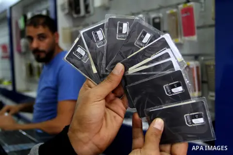 A Palestinian man displays SIM cards of Cellcom and Partner from Israeli cellular providers, in a mobile phone shop in Rafah in the southern Gaza strip, on November 20, 2016. Interior Ministry in Gaza are trying to stop...