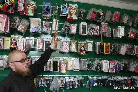 A Palestinian man work at his mobile phone shop in Rafah in the southern Gaza strip, on November 20, 2016. Interior Ministry in Gaza are trying to stop the sale and distribution of pre-paid SIM cards from Israeli cellula...