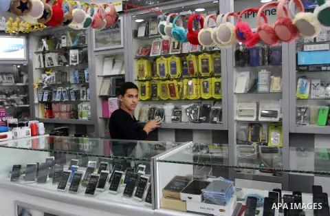 A Palestinian man work at his mobile phone shop in Rafah in the southern Gaza strip, on November 20, 2016. Interior Ministry in Gaza are trying to stop the sale and distribution of pre-paid SIM cards from Israeli cellula...