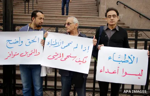 Egyptian doctors hold banners during a protest against shortage of medical supplies, outside the State Council's building, Egypt's highest administrative court, in Cairo on Nov. 20, 2016. Doctors are being told to reuse...
