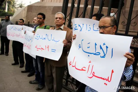 Egyptian doctors hold banners during a protest against shortage of medical supplies, outside the State Council's building, Egypt's highest administrative court, in Cairo on Nov. 20, 2016. Doctors are being told to reuse...