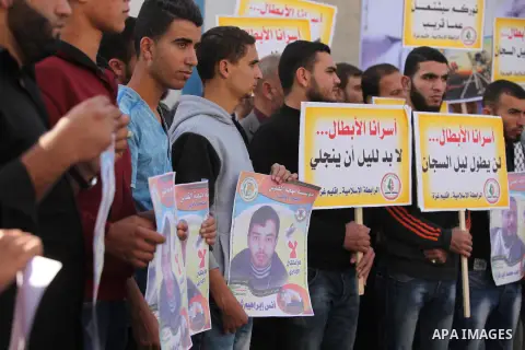 Palestinians hold banners during a protest to show solidarity with Palestinian prisoners on hunger strike in Israeli Jails, in front of the high commissioner for human rights headquarters in Gaza City, on November 22, 20...
